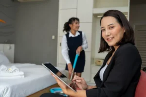 Supervisora organizando las actividades de limpieza de cuartos gracias al uso de un sistema de control hotelero especializado.