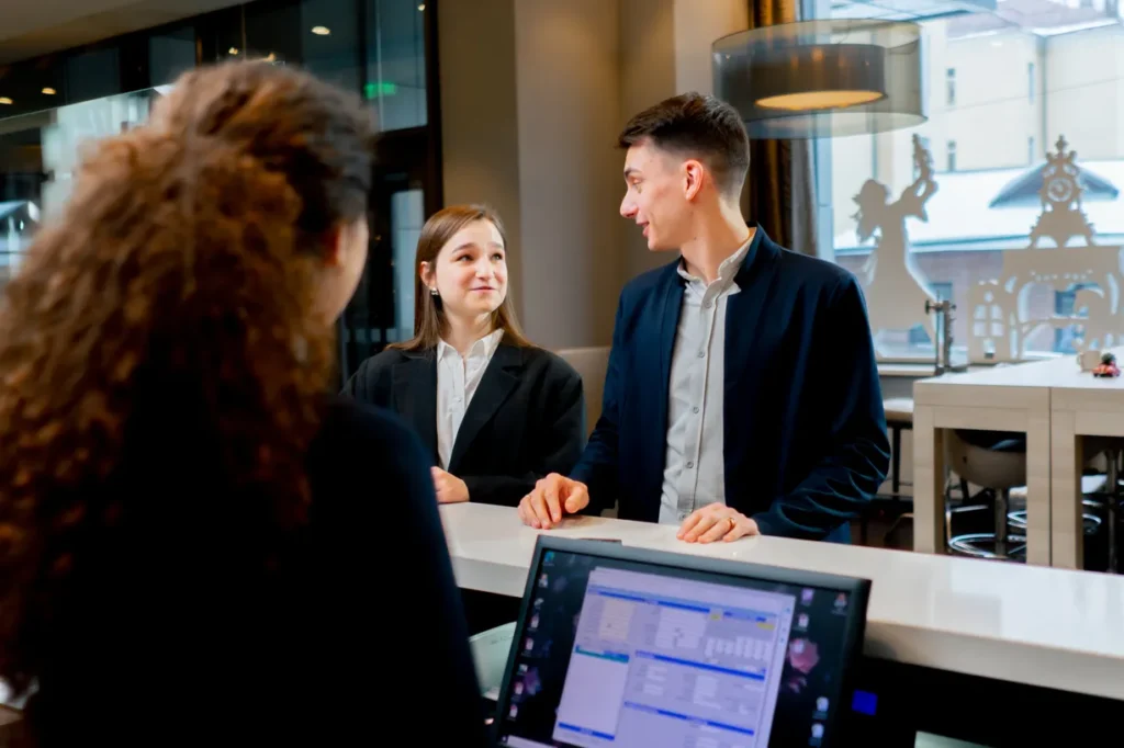 Fotografía de una recepcionista de un hotel que cuenta con los 10 beneficios de un PMS integrado con Channel Manager y POS