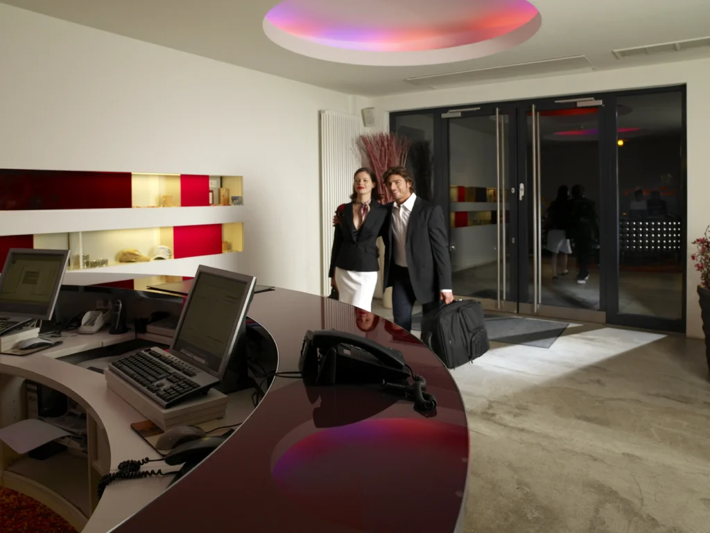 Fotografía dentro del lobby de un hotel con huéspedes conociendo las diferencias entre un hotel y un motel