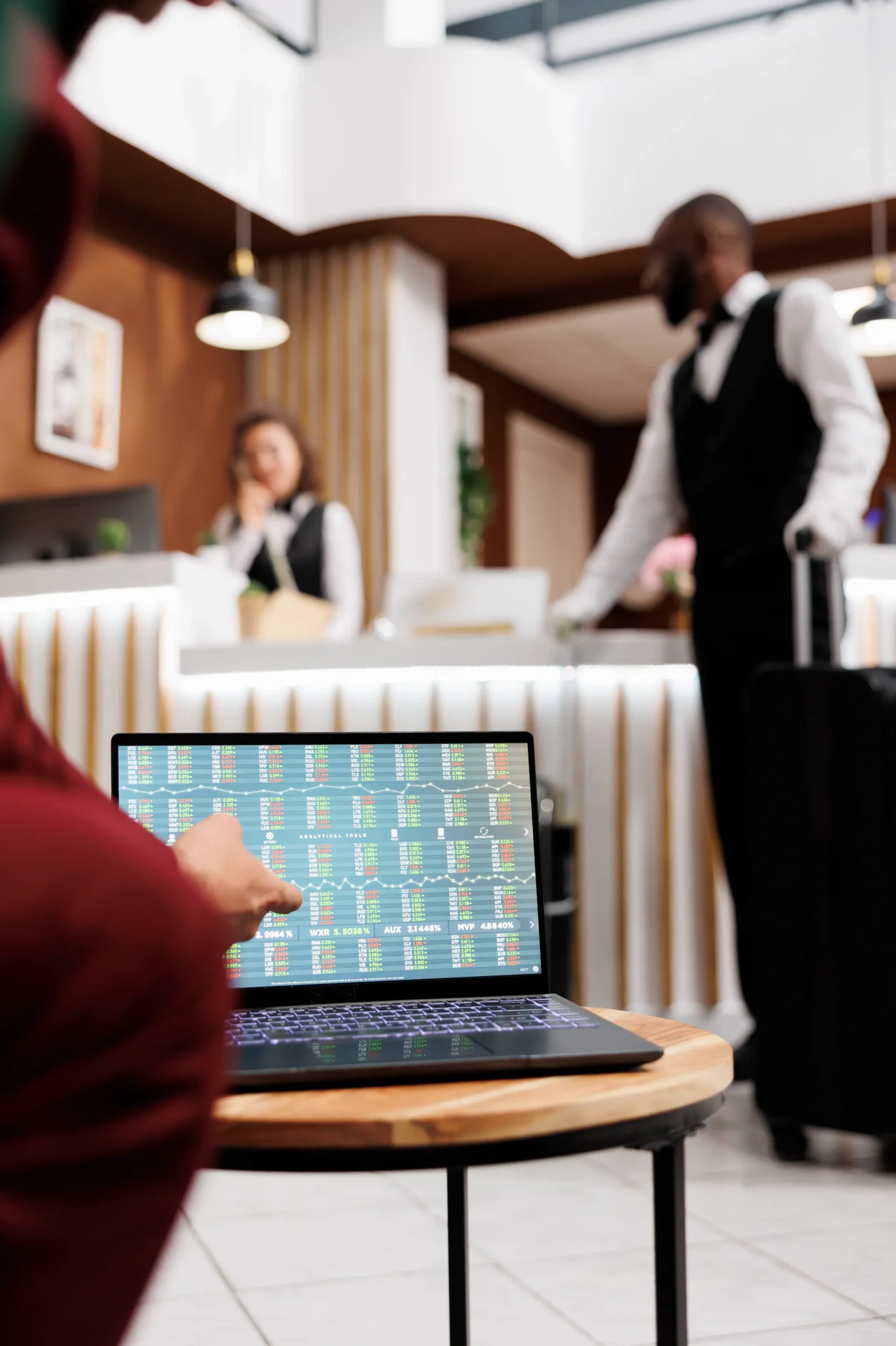 Fotografía de las manos de un colaborador de hotel analizando el motor de reservas en su laptop