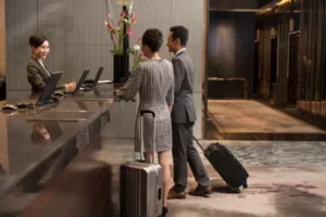 Foto de dos huéspedes en recepción de hotel que conoce que es un motor de reservas y lo implementa en su sistema