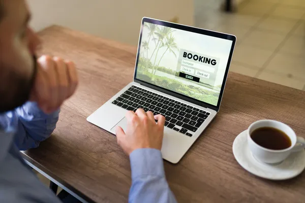 Foto de un joven analizando un booking en su laptop para entender mejor sobre el GDS, OTA y metabuscador